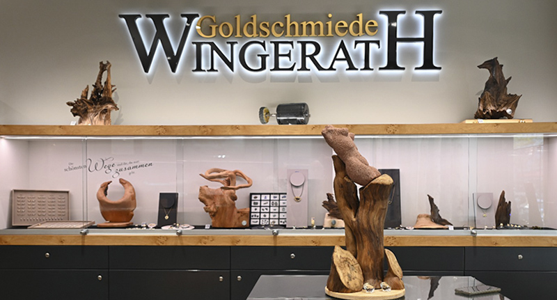 Verkaufsraum der Goldschmiede Wingerath mit Holzskulpturen von Rudi Menschen zwischen den Schmuckvitrinen